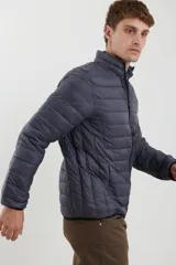 Campera puffer azul marino con cuello alto, cierre frontal con cremallera y bolsillos laterales con cierre.