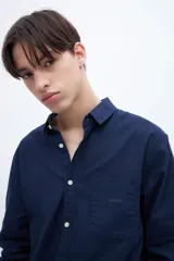 Camisa celeste de algodón, corte regular fit, con cuello solapa clásico, manga larga, bolsillo en el pecho y botones personalizados.