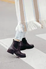 Bota tipo chelsea de cuero color marrón oscuro, con paneles laterales elásticos y suela track robusta con plataforma.