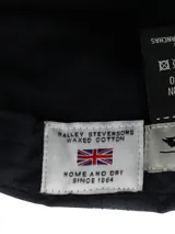 Gorra tipo baseball color azul marino, confeccionada en canvas engrasado impermeable con forro interior de algodón orgánico. Presenta un diseño clásico de seis paneles con costuras reforzadas en la visera y un pequeño logo bordado al tono en el panel frontal.