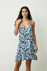 Vestido corto sin mangas con tirantes finos, escote redondo y diseño estampado en tonos azul, negro y blanco, con detalle de volados en el borde inferior.