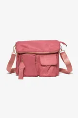 Cartera bandolera de tela color rosa, con múltiples bolsillos frontales, cierre principal y correa ajustable al tono.