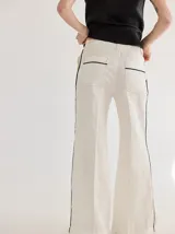 Pantalón de lino azul con corte palazzo y vivos a contratono color beige en los laterales.