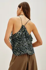 Top de tirantes finos con estampado batik en tonos oscuros y destellos metalizados. Presenta un escote en V decorado con aplicaciones de encaje floral y volados en los laterales.