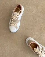 Sneakers de mujer estilo deportivo y urbano, color negro con detalles en beige claro. Presentan puntera y talón en negro, cuerpo principal en negro, y estrella lateral, cordones y tira de velcro en beige claro. La suela es blanca y el interior negro con la inscripción "LUCY IN THE SKY".