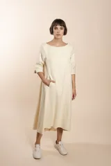 Vestido midi acampanado de lana fina sin teñir, con cuello bote, mangas tres cuartos con tajo y bolsillos laterales. Diseño forrado con vuelo y movimiento.