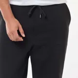 Conjunto deportivo de felpa color negro, compuesto por un buzo canguro con cierre y capucha y un pantalón jogger a juego.