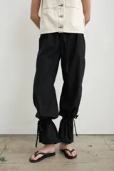 Pantalón recto marrón de lino y algodón, con tiras regulables en los tobillos para ajustar.