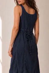 Vestido largo de lino azul marino, sin mangas, con escote en V y corte en la cintura. Presenta costuras pespunteadas a la vista y falda amplia con vuelo.