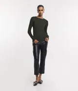 Suéter de punto color rosado, con cuello barco, mangas largas y puños con botones decorativos. El dobladillo también es acanalado.