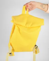 Mochila amarilla de tela con tiras de cuero color beige.