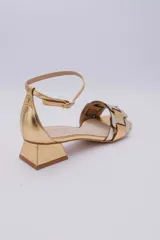 Sandalias bajas doradas con tiras anchas entrecruzadas en dorado y plateado, con pulsera al tobillo y taco cuadrado bajo.