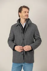 Chaquetón de lana color gris con pechera desmontable, cuello solapa y cierre frontal con botones y cremallera.
