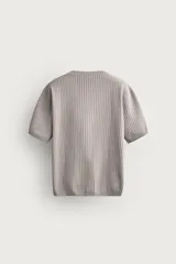 Jersey de punto de manga corta con textura acanalada, cuello redondo y terminaciones en rib en cuello, mangas y ruedo.