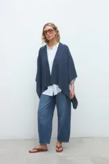 Ruana de punto azul marino, de diseño abierto y corte amplio y fluido.
