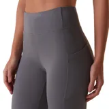 Calza deportiva de tiro alto con bolsillos laterales, confeccionada en tejido elástico de alta compresión, ideal para entrenamiento.