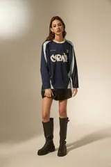 Remera de manga larga estilo deportivo, confeccionada en tejido técnico. Presenta un diseño color block en tonos bordó y rosa, con cuello mao y estampado gráfico frontal en color blanco.