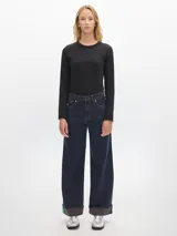 Jean de pierna ancha de denim raw, tiro medio-alto y dobladillo en bajos.