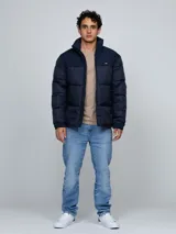 Campera puffer azul marino de cuello alto, acolchada y con cierre frontal de cremallera. Presenta bolsillos laterales con ojal y el logo bordado de la marca en el pecho.