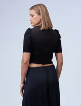 Top negro de símil gamuza, marca Tahari, con espalda con abertura central y cierre invisible.