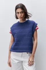Chaleco tejido azul de calce relajado, silueta recta, cuello redondo, hombros caídos y diseño de punto con textura calada.