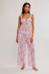 Conjunto de dos piezas de algodón con estampado floral en tonos rosados sobre base blanca, compuesto por una camisola sin mangas con escote cuadrado y lazo frontal, y pantalón largo de corte ancho.
