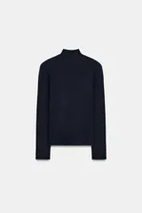 Jersey de punto de cuello subido y manga larga con hombreras. Presenta un diseño de espalda abierta con detalle de nudo.