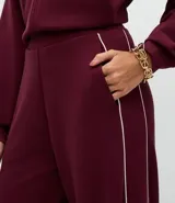 Pantalón wide leg color bordó con cintura estructurada y detalle de piping lateral en color blanco. Confeccionado en tejido de algodón, viscosa y poliéster.