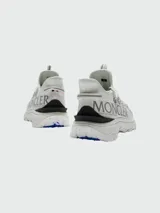 Championes Moncler modelo Trailgrip Lite, color blanco, con diseño técnico de trail running, cordones estilo cuerda y suela con relieve marcado.