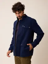 Campera de estilo safari en color azul marino, confeccionada en algodón. Presenta cuello alto, cierre frontal con cremallera y cuatro bolsillos delanteros con solapa y botones metálicos.