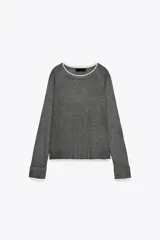 Jersey de punto verde militar con efecto doble, escote redondo y mangas largas con detalles en blanco en el cuello, puños y ruedo.