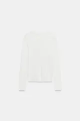 Camiseta slim fit de algodón color blanco, con cuello subido, manga larga y cierre frontal con una hilera de pequeños botones.