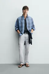 Camisa de corte regular fit confeccionada en tejido ligero de algodón, con estampado de cuadros en tonos azules y grises. Presenta cuello abotonado, manga larga con puños abotonados, bolsillo plastrón en el pecho y cierre frontal de botones.