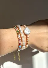 Pulsera de acero dorado con cuentas de vidrio de colores y perlas cultivadas.