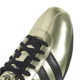 Championes Adidas modelo Tokyo, con acabado metalizado en color dorado y detalles en negro. Presenta las icónicas tres tiras laterales, cordones y suela de goma en color negro.