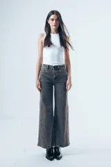 Jean wide leg negro de tiro alto, con paneles laterales en el ruedo que aportan mayor amplitud y movimiento.