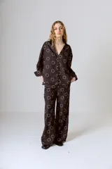 Pantalón de vestir negro con estampado de círculos blancos, corte holgado y tiro alto.