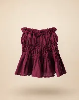 Falda corta de lino color bordó con diseño fruncido en la cintura y el cuerpo, y un amplio volado en el ruedo.