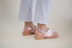 Sandalias de cuero color rosa metalizado, con puntera descubierta, tira ancha sobre el empeine y tira trasera con hebilla.
