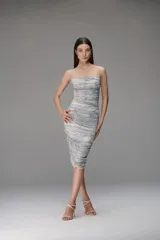 Vestido midi de tul con diseño drapeado en toda la prenda, escote recto y breteles finos. Presenta un estampado sutil en tonos azulados y grisáceos, con un ajuste ceñido al cuerpo.