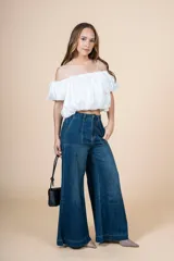 Blusa blanca con escote elástico que permite usarla con hombros descubiertos o más alta.