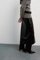 Falda midi de tiro alto con diseño de tubo, confeccionada en material con efecto piel. Presenta una abertura frontal en el bajo y cierre con cremallera oculta en la costura.