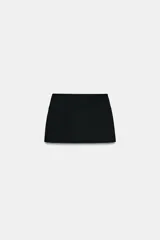 Falda pantalón de tiro bajo con diseño minimalista, falsos bolsillos de vivo en el delantero y cierre lateral con cremallera oculta.