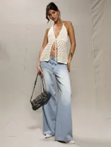 Top tejido de hilo color crudo, con escote halter y espalda descubierta. Se ata en el cuello y en la cintura.