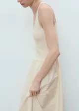 Vestido largo combinado de color marfil, sin mangas, con tirantes anchos, cuello escotado y panel fruncido en la cintura con diseño evasé en la falda.