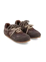 Sneaker urbano de diseño multistractural confeccionado en una combinación de cueros en tonos marrón, chocolate y tostado. Cuenta con cordones bicolores, suela dentada de goma que se extiende hacia el talón y detalles de texturas superpuestas.
