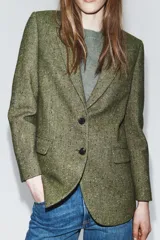 Blazer de Zara confeccionado en hilatura con lana, con diseño de espiga en tonos marrones. Presenta cuello solapa, manga larga con botones, bolsillo de vivo en el pecho y bolsillos delanteros con solapa. Cierre frontal con botones y forro interior negro.