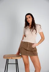 Remera beige de tejido calado con cuello polo y mangas cortas.