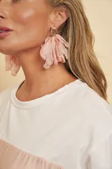 Aros colgantes con piedra en forma de lágrima en la parte superior y grandes pétalos de tela rosados en cascada.