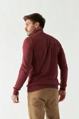 Campera tejida azul marino con cierre frontal, cuello alto y mangas largas.